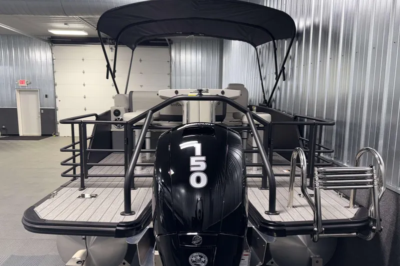 Slide: The Image of 2026 Sylvan MIRAGE X3 DLZ BAR pontoon boat in a metal-walled showroom. - 28