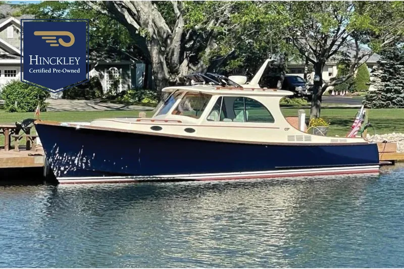 The Image of 2017 Hinckley Picnic Boat 37 MKIII docked, certified pre-owned, with lush greenery in the background. - 0