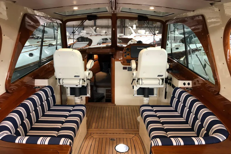Slide: The Image of Interior of 2017 Hinckley Picnic Boat 37 MKIII with striped seating and wooden finishes. - 11