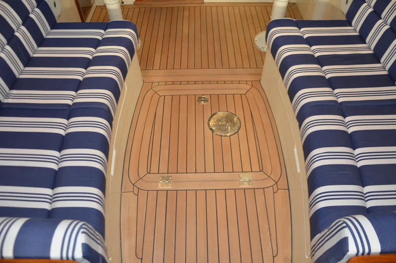 Slide: The Image of 2017 Hinckley Picnic Boat 37 MKIII interior with striped seating and teak flooring. - 18
