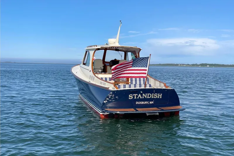 Slide: The Image of 2017 Hinckley Picnic Boat 37 MKIII on calm water, American flag displayed. - 2