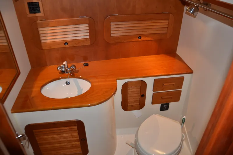 Slide: The Image of 2017 Hinckley Picnic Boat 37 MKIII bathroom with wooden cabinetry and modern fixtures. - 21