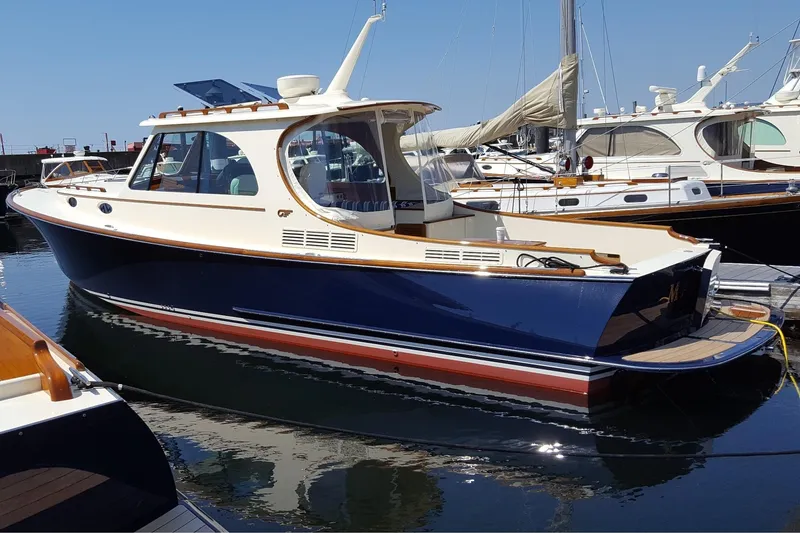 Slide: The Image of 2017 Hinckley Picnic Boat 37 MKIII docked in marina, elegant design, blue hull. - 8