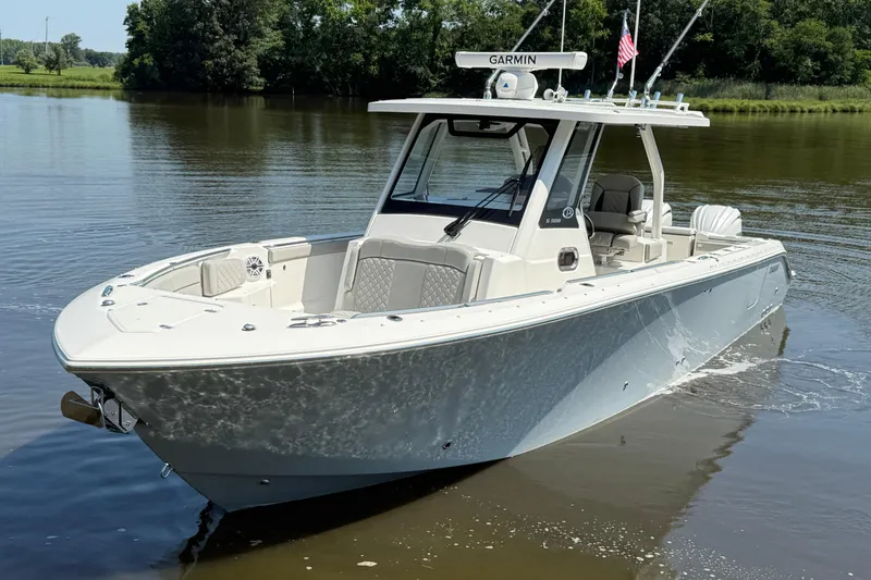 Slide: The Image of 2024 Pursuit S 328 Sport boat on calm water, featuring sleek design and modern amenities. - 11