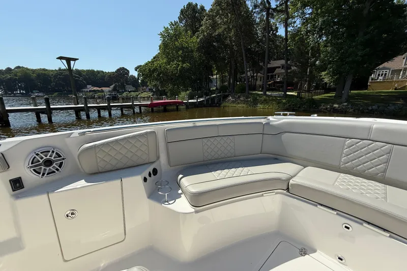 Slide: The Image of 2024 Pursuit S 328 Sport boat interior with cushioned seating and waterfront view. - 18