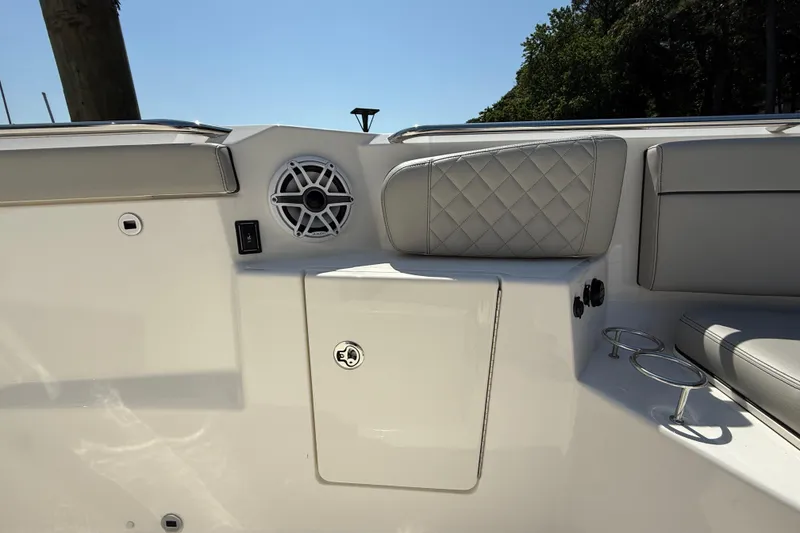 Slide: The Image of 2024 Pursuit S 328 Sport boat interior with speaker, cushioned seating, and cup holders. - 20