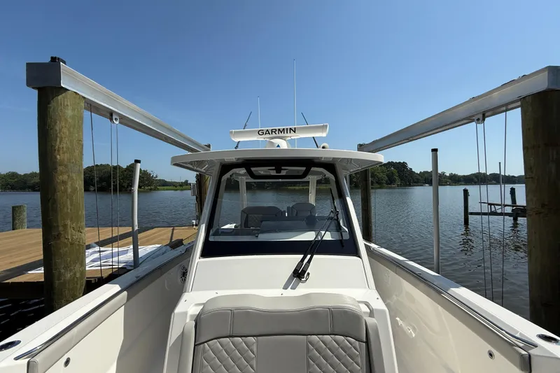 Slide: The Image of 2024 Pursuit S 328 Sport boat docked on a sunny day by the water. - 24