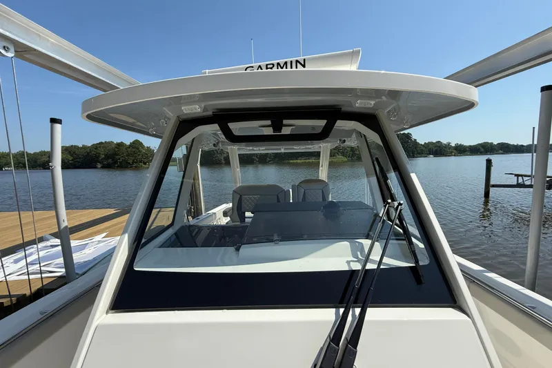 Slide: The Image of 2024 Pursuit S 328 Sport boat docked on a sunny day, featuring Garmin equipment. - 25