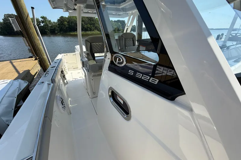 Slide: The Image of 2024 Pursuit S 328 Sport boat docked by a serene lake. - 28