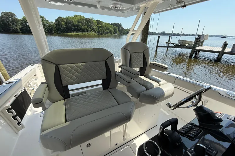 Slide: The Image of 2024 Pursuit S 328 Sport boat interior with luxurious seating and scenic water view. - 31