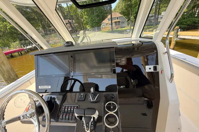 Slide: The Image of 2024 Pursuit S 328 Sport boat cockpit with modern navigation displays and controls. - 33