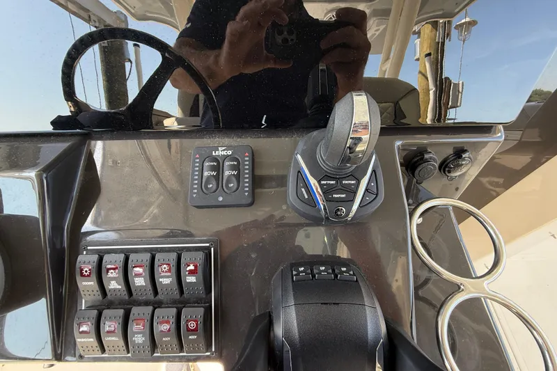 Slide: The Image of 2024 Pursuit S 328 Sport boat dashboard with controls and switches. - 36