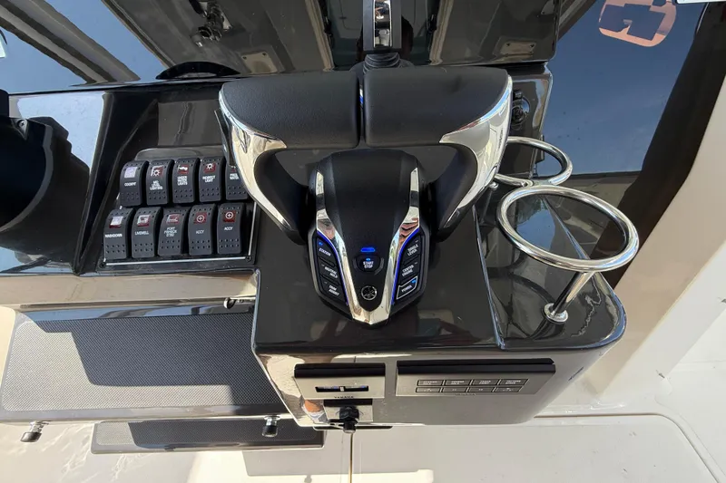 Slide: The Image of 2024 Pursuit S 328 Sport boat control panel with throttle and switches. - 37