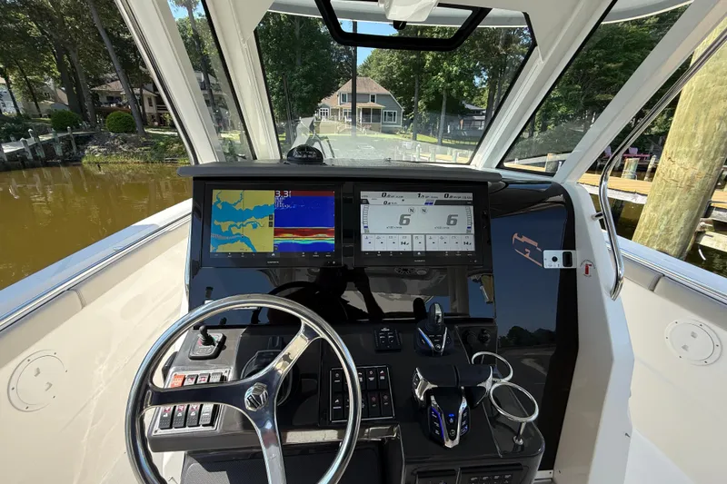 Slide: The Image of 2024 Pursuit S 328 Sport boat dashboard with navigation screens and controls. - 41