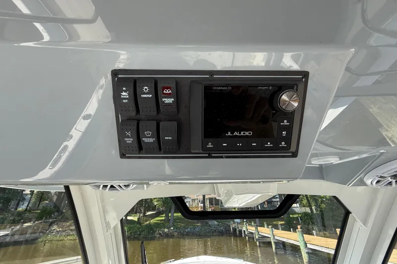 Slide: The Image of 2024 Pursuit S 328 Sport boat dashboard with JL Audio system and control panel. - 44