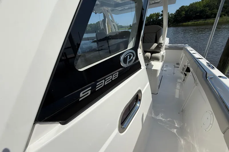 Slide: The Image of 2024 Pursuit S 328 Sport boat, sleek design, docked by a scenic river. - 48