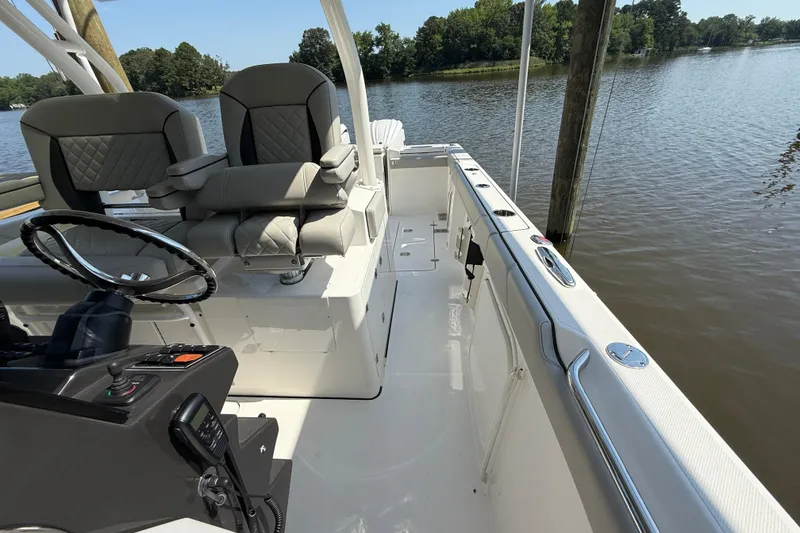 Slide: The Image of 2024 Pursuit S 328 Sport boat interior with steering wheel and seating by the water. - 49