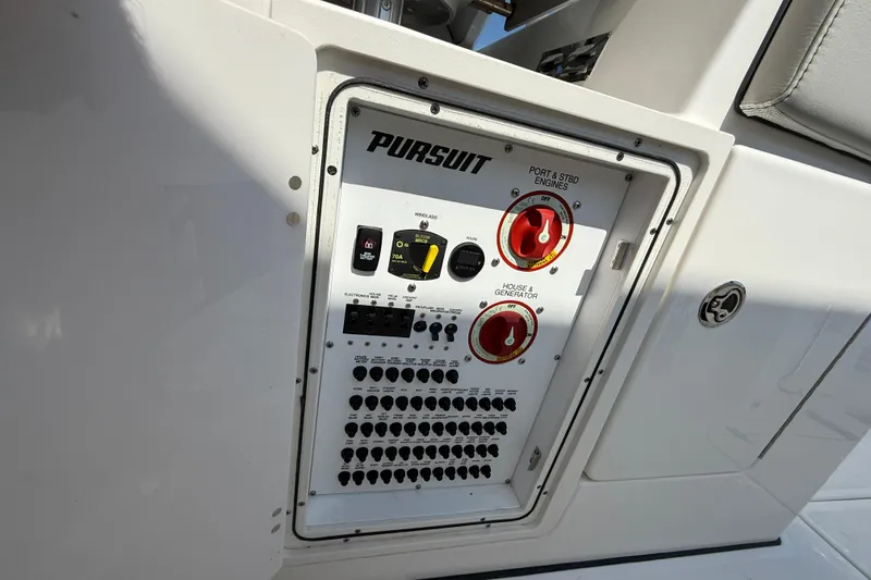 Slide: The Image of 2024 Pursuit S 328 Sport boat control panel with switches and dials. - 51