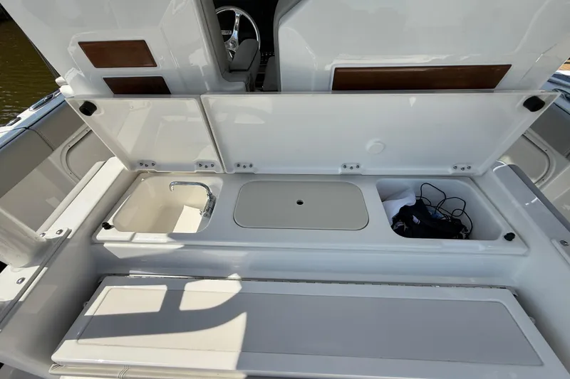 Slide: The Image of 2024 Pursuit S 328 Sport boat interior with sink and storage compartments. - 54