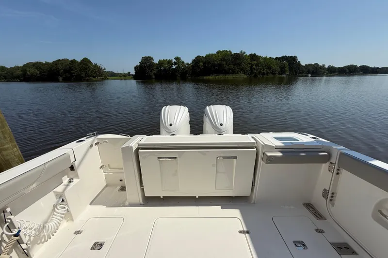 Slide: The Image of 2024 Pursuit S 328 Sport boat with dual engines on a calm lake. - 56