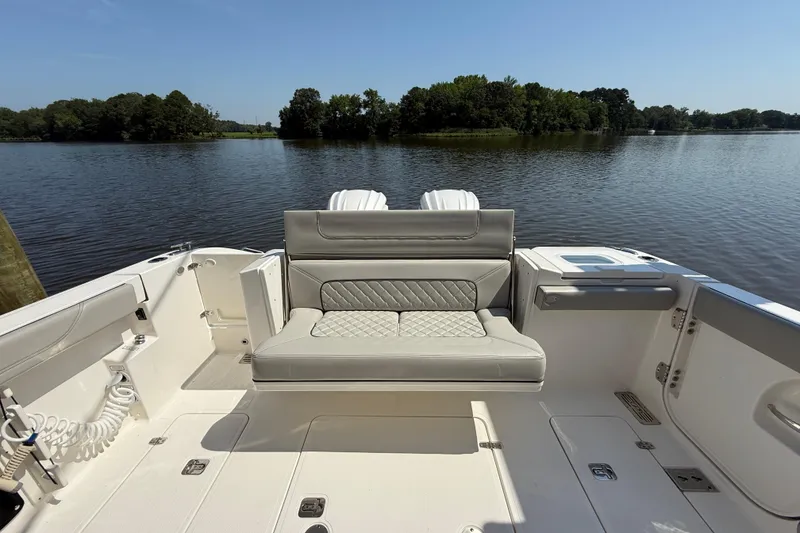 Slide: The Image of 2024 Pursuit S 328 Sport boat interior with seating, overlooking a serene lake. - 57