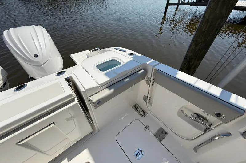 Slide: The Image of 2024 Pursuit S 328 Sport boat deck with engine and storage compartments. - 58
