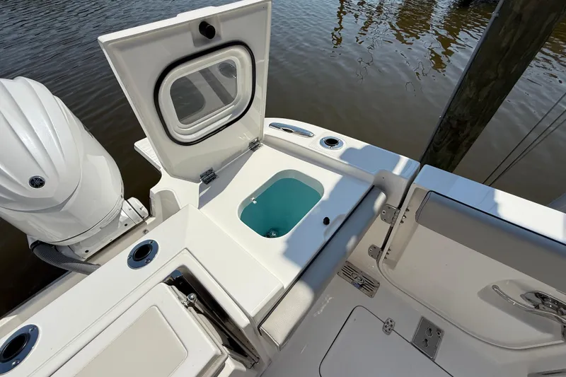 Slide: The Image of 2024 Pursuit S 328 Sport boat with open hatch and engine, docked by water. - 59