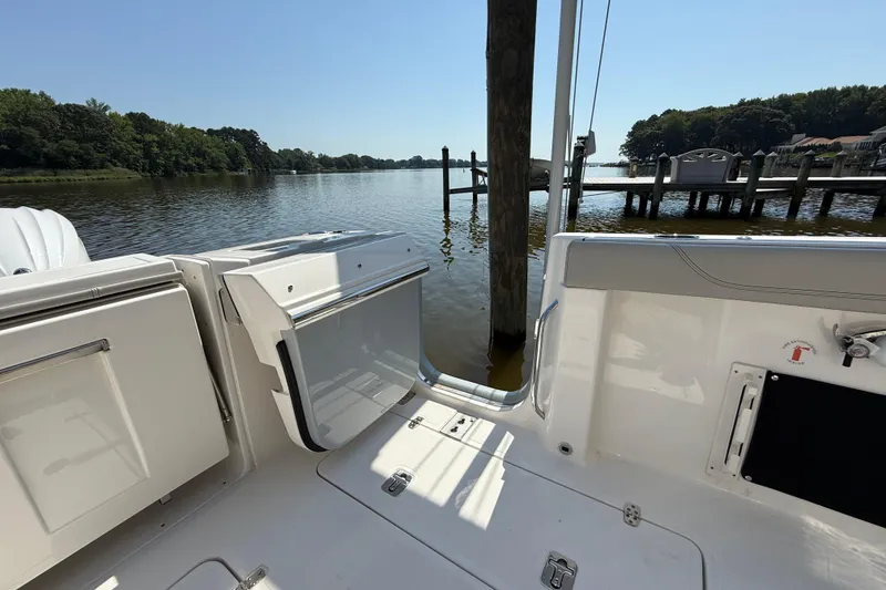 Slide: The Image of 2024 Pursuit S 328 Sport boat docked by a serene lake with lush greenery. - 62