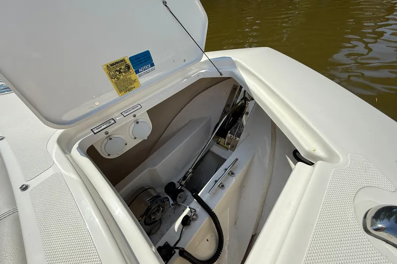 Slide: The Image of 2024 Pursuit S 328 Sport boat anchor compartment open, showing storage and equipment. - 63
