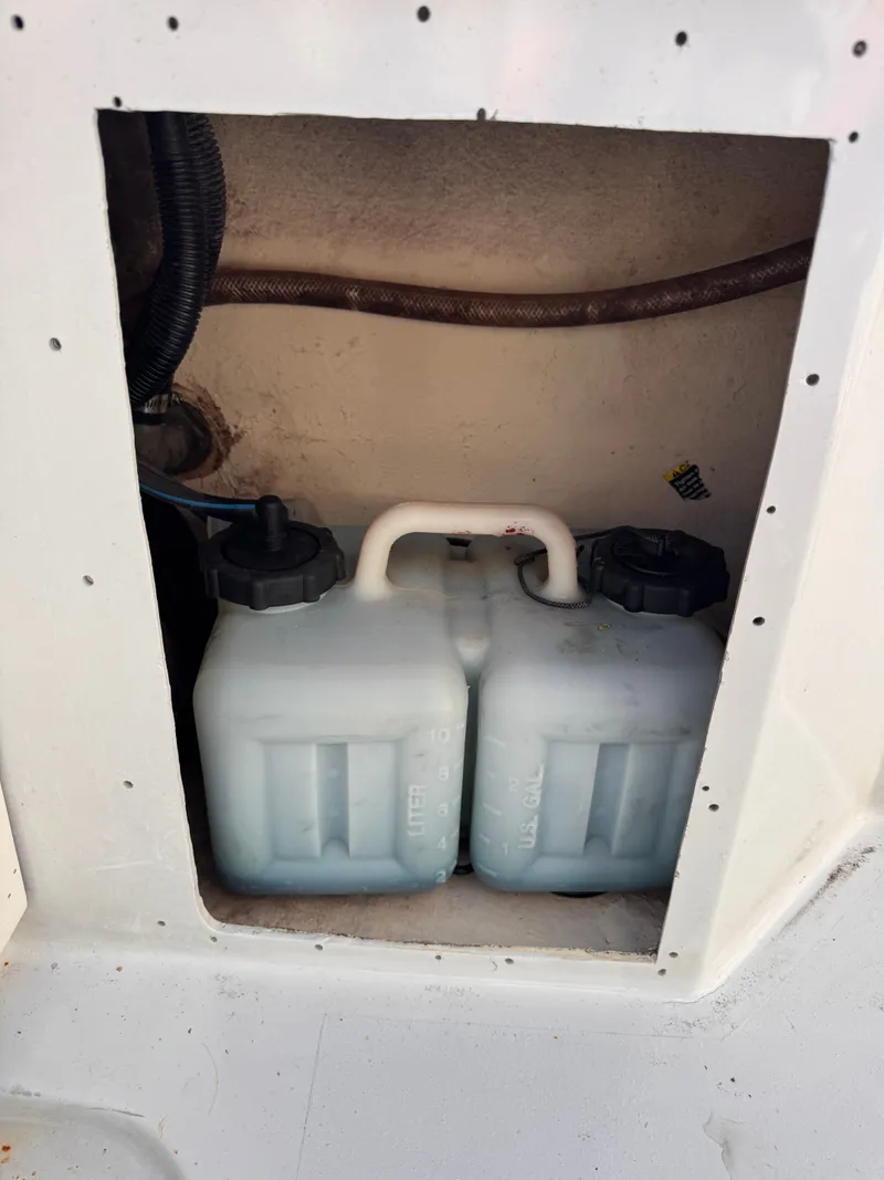 Slide: The Image of Two white plastic containers inside a 1988 KenCraft Challenger 215 boat compartment. - 12