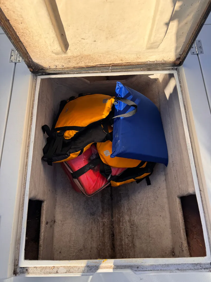 Slide: The Image of Storage compartment on 1988 KenCraft Challenger 215 with life jackets and cushions. - 13