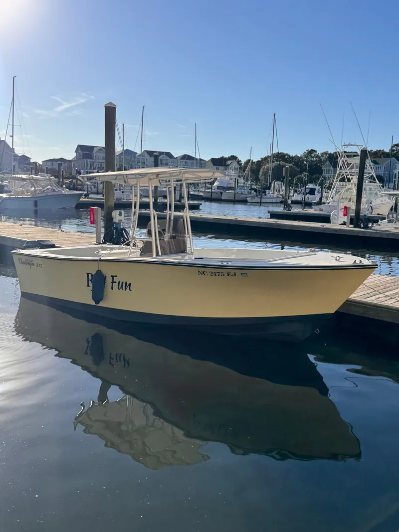 Slide: The Image of 1988 KenCraft Challenger 215 boat docked in a marina under clear blue sky. - 2