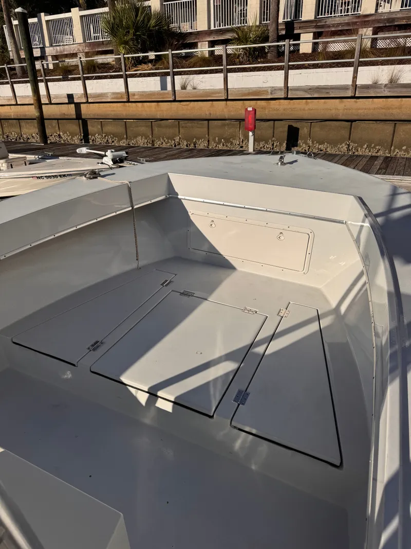 Slide: The Image of 1988 KenCraft Challenger 215 boat deck with storage compartments, docked by a wooden pier. - 5
