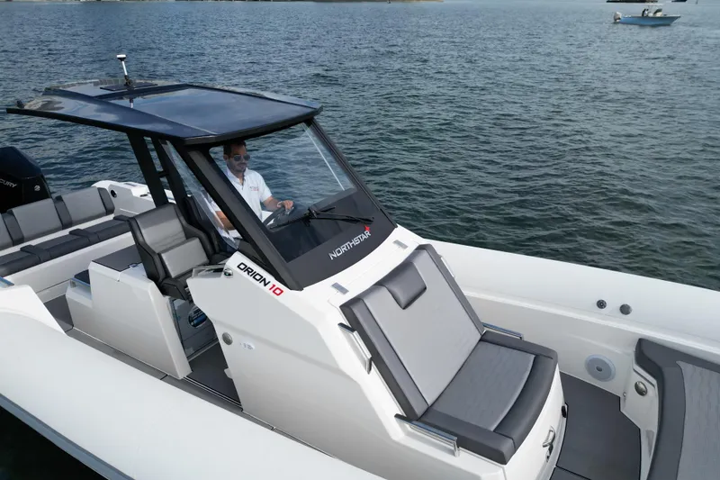 Slide: The Image of 2026 Northstar ORION 10 boat cruising on open water with a person at the helm. - 7