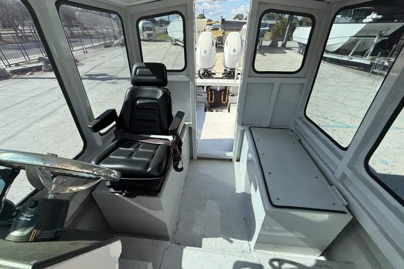 Slide: The Image of Interior of a 1996 Geo Marine 24ft Work Boat with steering wheel and seating. - 10
