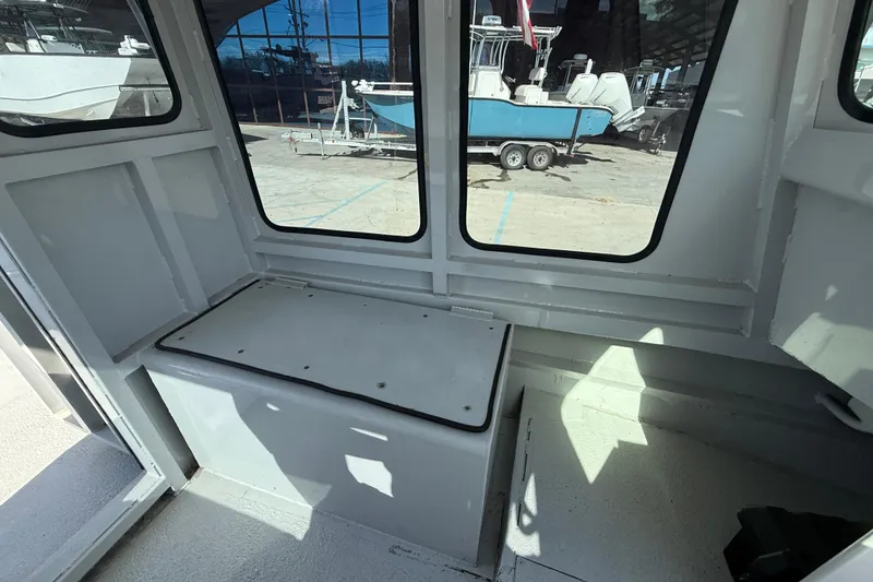 Slide: The Image of Interior of a 1996 Geo Marine 24ft Work Boat, featuring seating and windows. - 11