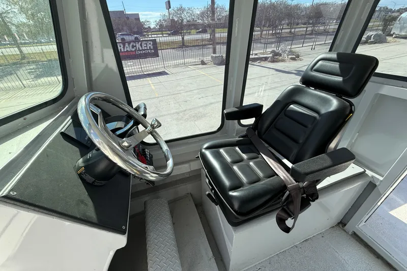 Slide: The Image of Interior of a 1996 Geo Marine 24ft Work Boat with steering wheel and captain's chair. - 13