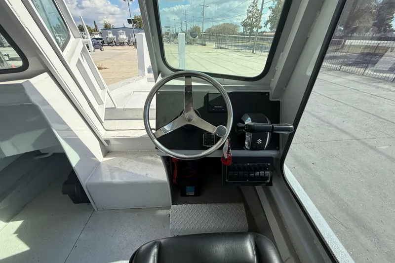 Slide: The Image of Interior view of a 1996 Geo Marine 24ft Work Boat cockpit with steering wheel and controls. - 16