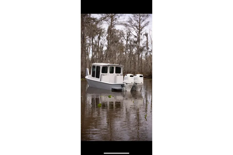 Slide: The Image of Geo Marine 24ft Work Boat, 1996 model, on a calm waterway surrounded by trees. - 22