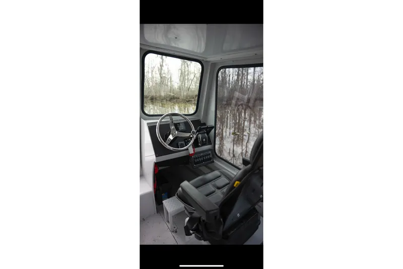 Slide: The Image of Interior of 1996 Geo Marine 24ft Work Boat, featuring steering wheel and control panel. - 23