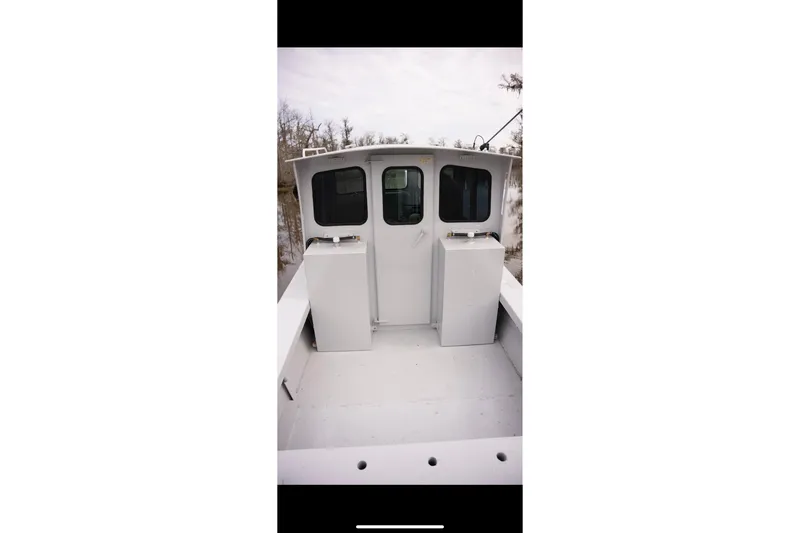 Slide: The Image of 1996 Geo Marine 24ft Work Boat with dual compartments, docked in a serene setting. - 24