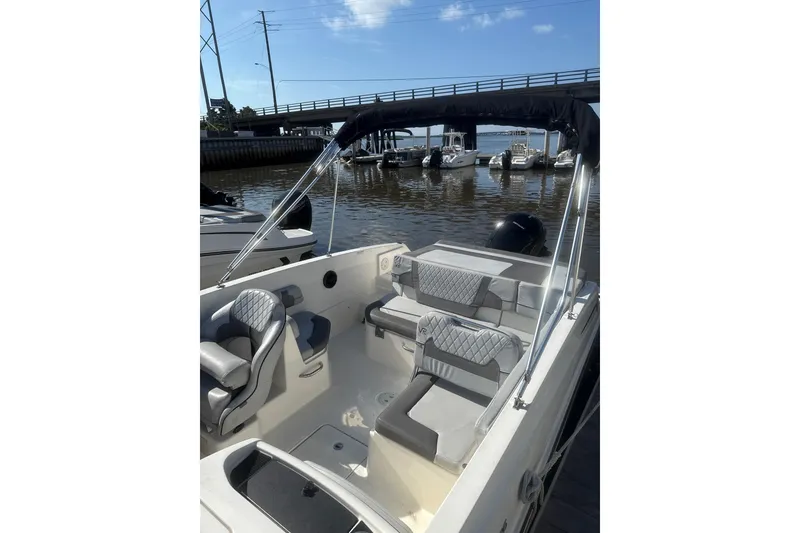 Slide: The Image of 2022 Bayliner VR6 Bowrider OB with sleek interior, docked by a marina. - 3