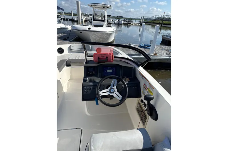 Slide: The Image of 2022 Bayliner VR6 Bowrider OB at dock, featuring steering console and modern design. - 4