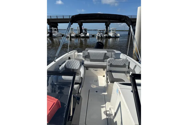 Slide: The Image of 2022 Bayliner VR6 Bowrider OB with spacious seating, docked near a bridge. - 6