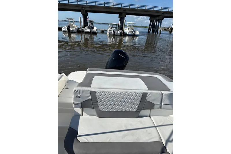 Slide: The Image of 2022 Bayliner VR6 Bowrider OB on water near docked boats and bridge. - 8