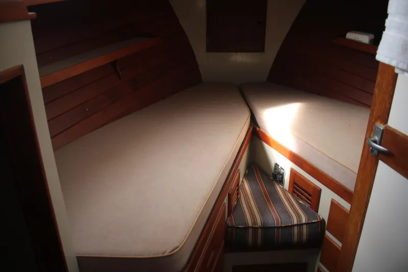 Slide: The Image of 1974 Grand Banks 42 Classic cabin interior with twin beds and wooden paneling. - 13