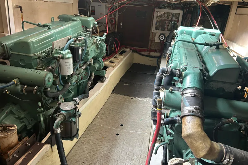 Slide: The Image of Engine room of a 1974 Grand Banks 42 Classic yacht, featuring dual engines. - 17
