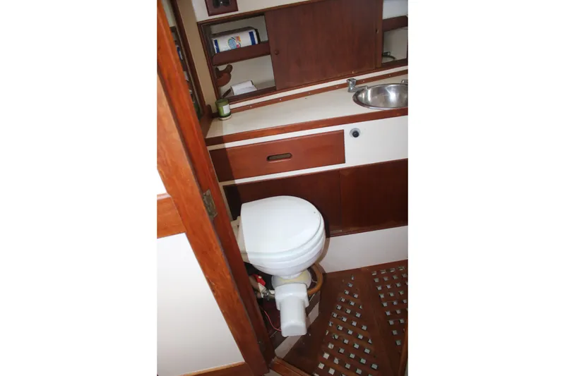 Slide: The Image of 1974 Grand Banks 42 Classic yacht bathroom with wooden cabinetry and compact sink. - 28