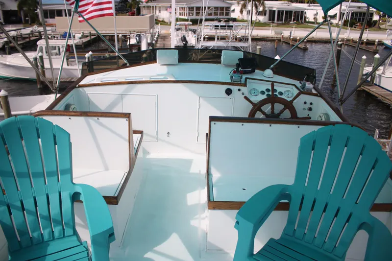 Slide: The Image of 1974 Grand Banks 42 Classic yacht deck with turquoise chairs and wooden steering wheel. - 7