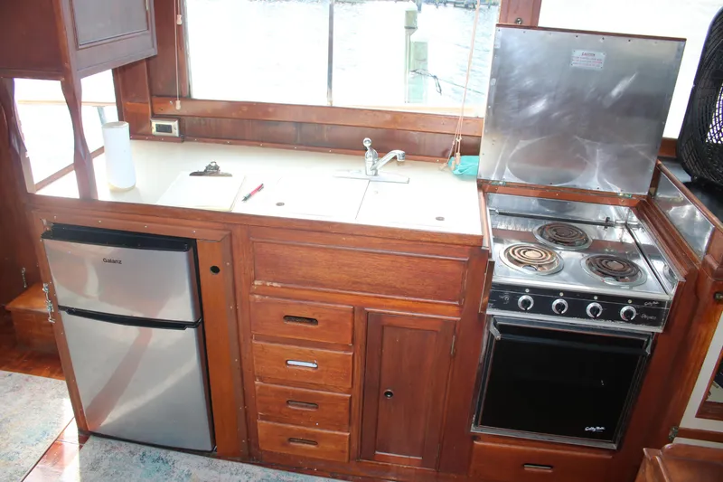 Slide: The Image of 1974 Grand Banks 42 Classic yacht kitchen with stove, fridge, and wooden cabinetry. - 8
